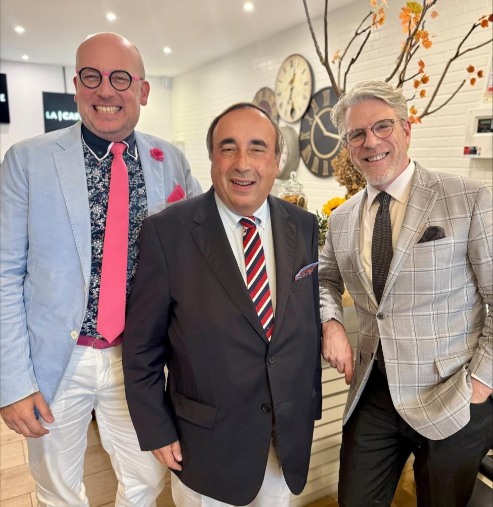 Three males wearing a jacket with tie smiling before the camera