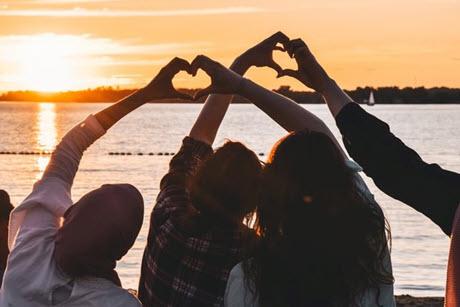 People near body of water at sunset