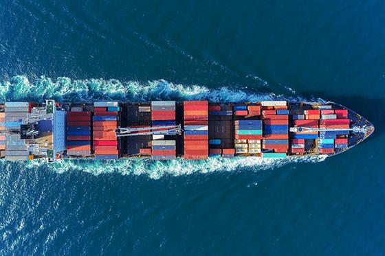 colorful container ship coursing through the ocean waves